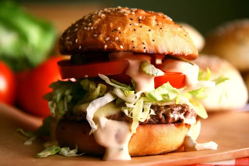 burger s rajcatem, salatem, masem syrem a omackou která vytéká