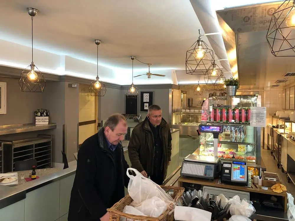Interier restaurace apetit, kde jsou vidět dva zákaznící jak si objednávají u pultu