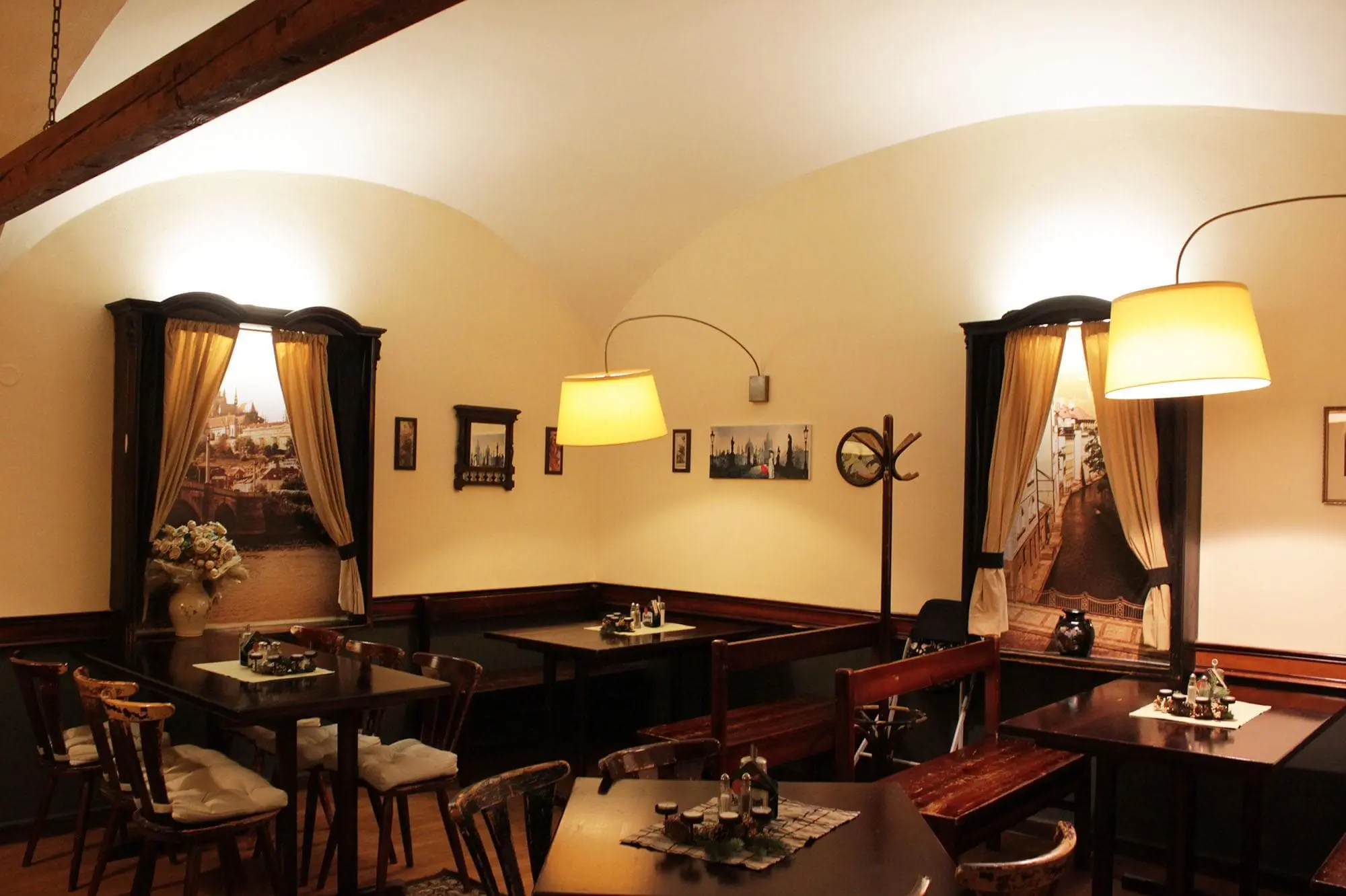  restaurace u červeného páva z vniřku, kde jsou vidět stoly a židle s lampami