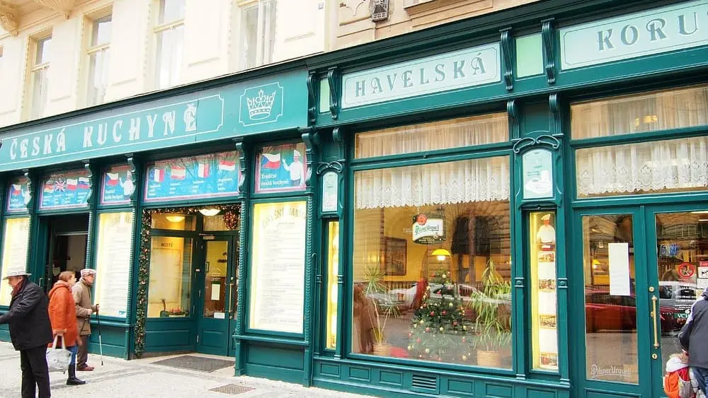   restaurace havelská koruny z pohledu z venku, kde jsou vidět jak lidé vchází do restaurace