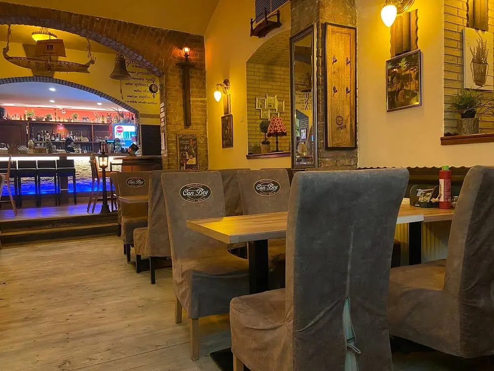 interier kebabarny, kde jsou zidle s potahem a stoly