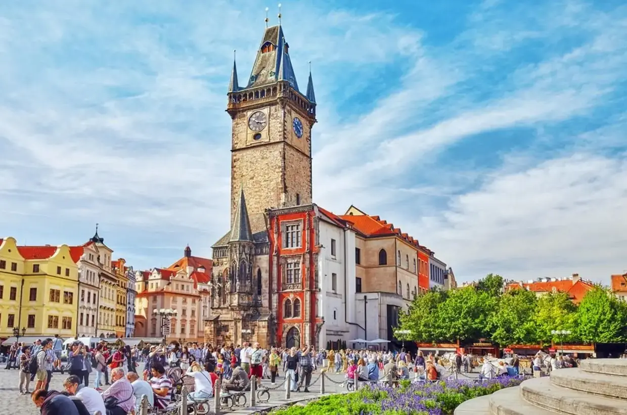 pohled na staromestskou radnici pri modre obloze s mnoho turisty